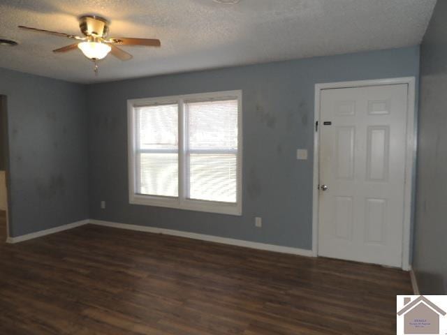 empty room featuring ceiling fan, dark hardwood / wood-style floors, and a textured ceiling