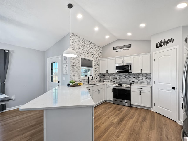 kitchen featuring sink, white cabinetry, decorative light fixtures, kitchen peninsula, and stainless steel appliances