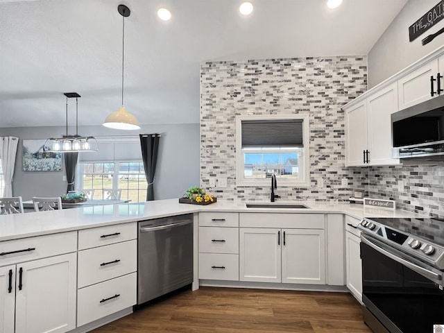 kitchen featuring sink, white cabinetry, plenty of natural light, stainless steel appliances, and decorative light fixtures