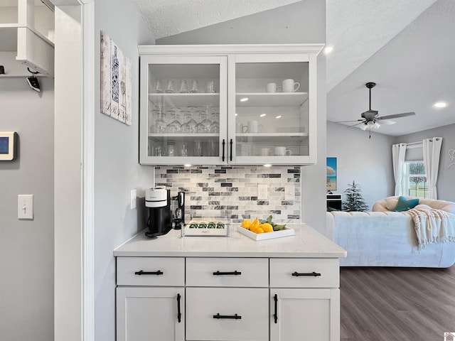 bar featuring backsplash, lofted ceiling, dark hardwood / wood-style floors, and white cabinets