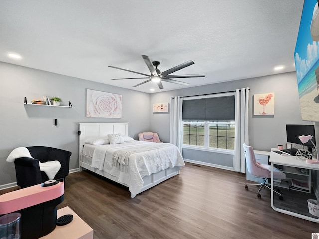 bedroom with dark wood-type flooring, a textured ceiling, and ceiling fan