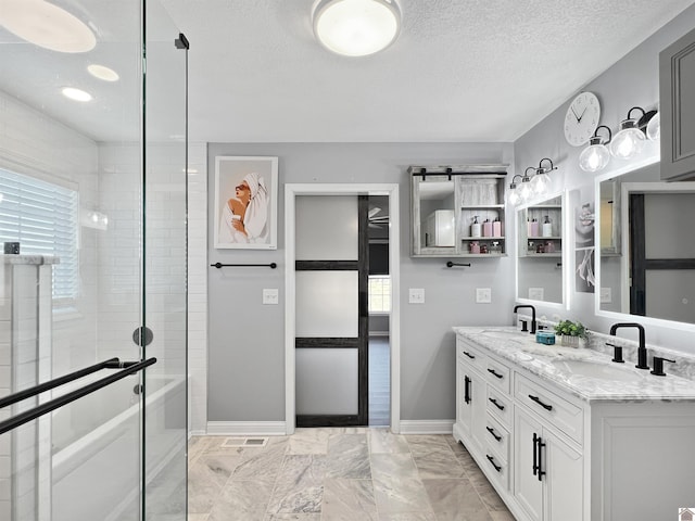 bathroom with vanity, a textured ceiling, and a tile shower