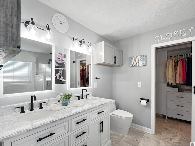 bathroom with vanity, a textured ceiling, and toilet