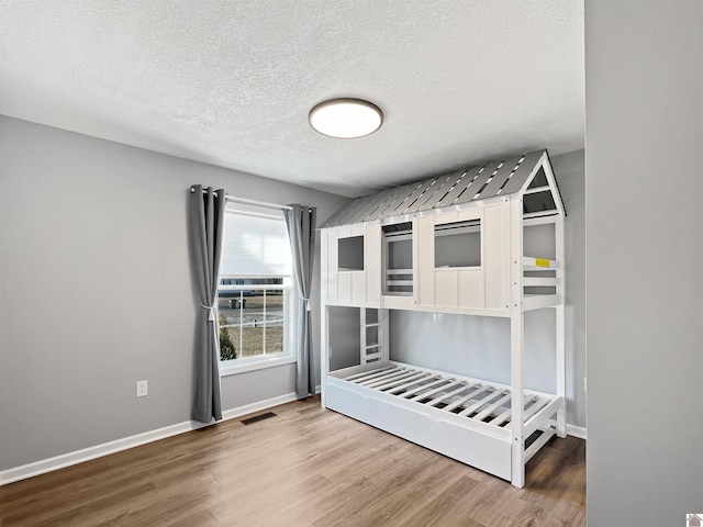 unfurnished bedroom featuring hardwood / wood-style flooring and a textured ceiling