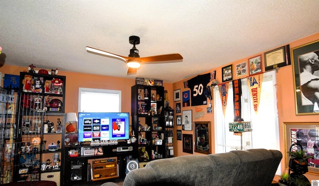 living room with ceiling fan and a textured ceiling