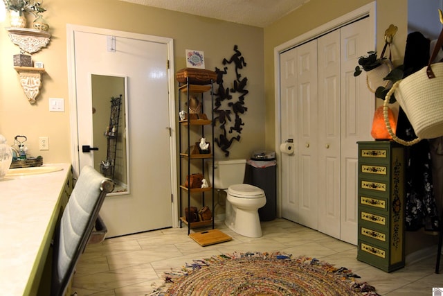 bathroom with vanity, a textured ceiling, and toilet