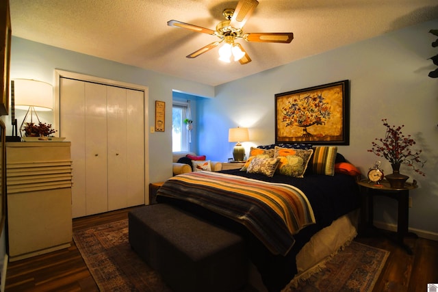 bedroom featuring dark wood-type flooring, ceiling fan, a closet, and a textured ceiling