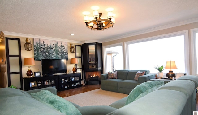 living room featuring crown molding, a chandelier, a fireplace, and dark hardwood / wood-style flooring