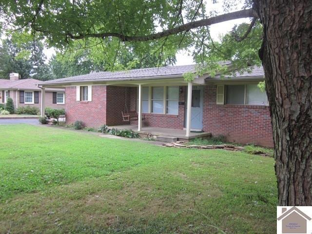 ranch-style home featuring a front yard and covered porch