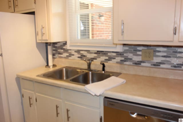 kitchen featuring dishwasher, sink, and backsplash