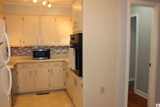 kitchen with white refrigerator, tasteful backsplash, ornamental molding, and oven