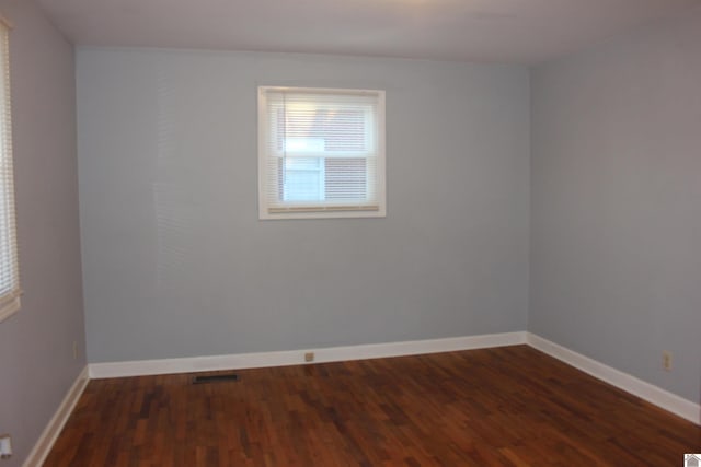 unfurnished room with dark hardwood / wood-style flooring