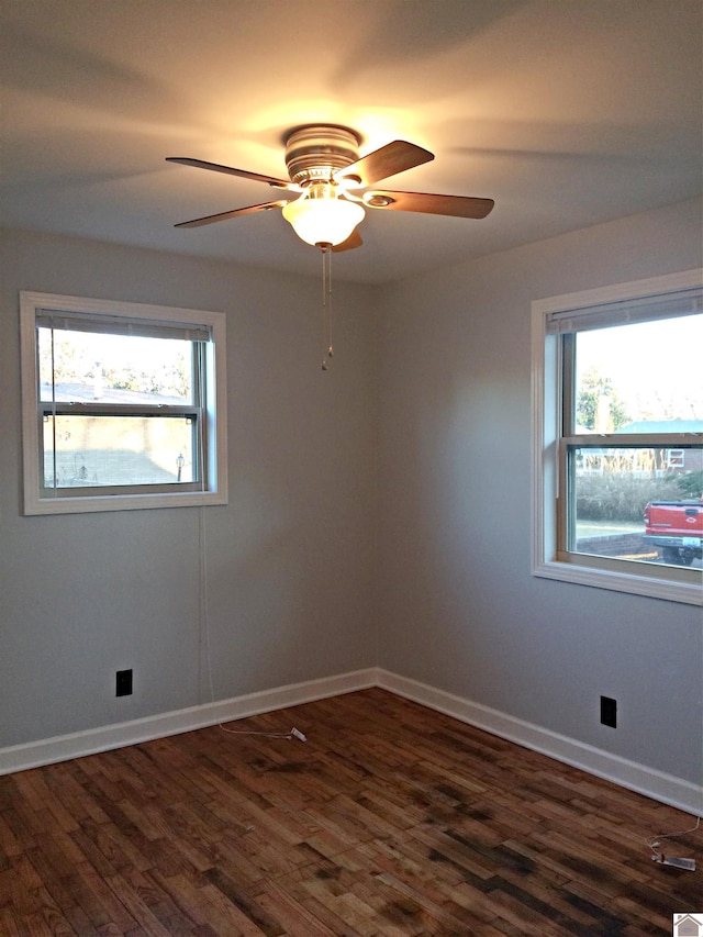 unfurnished room with ceiling fan, dark wood-type flooring, and a healthy amount of sunlight