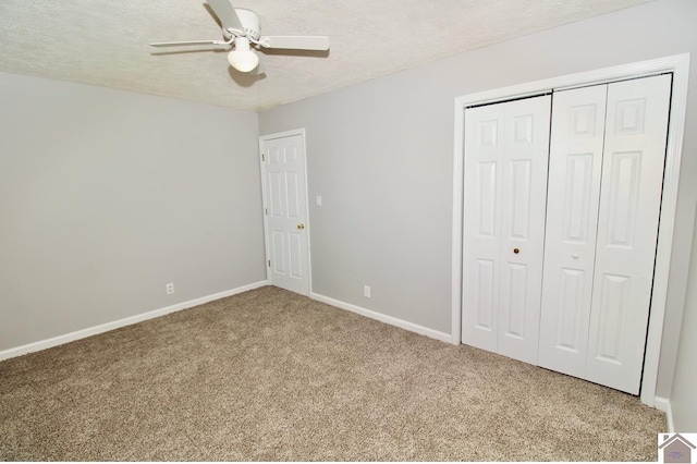 unfurnished bedroom featuring ceiling fan, carpet, a textured ceiling, and a closet