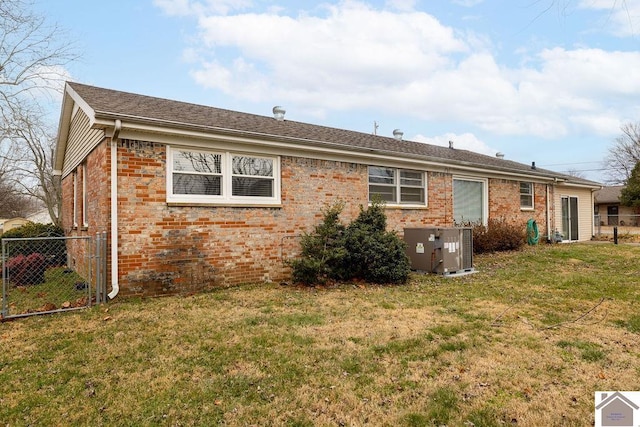 rear view of house featuring a yard and central air condition unit