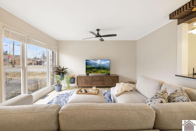 living room with crown molding, wood-type flooring, and ceiling fan