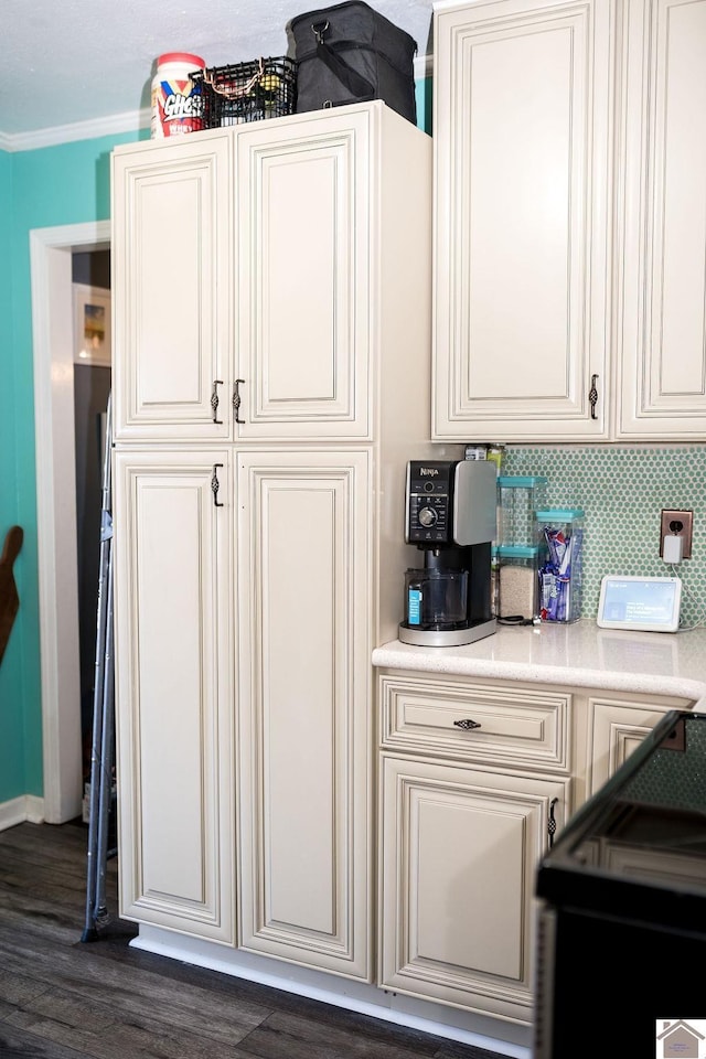 kitchen with dark wood-style flooring, light countertops, crown molding, and decorative backsplash