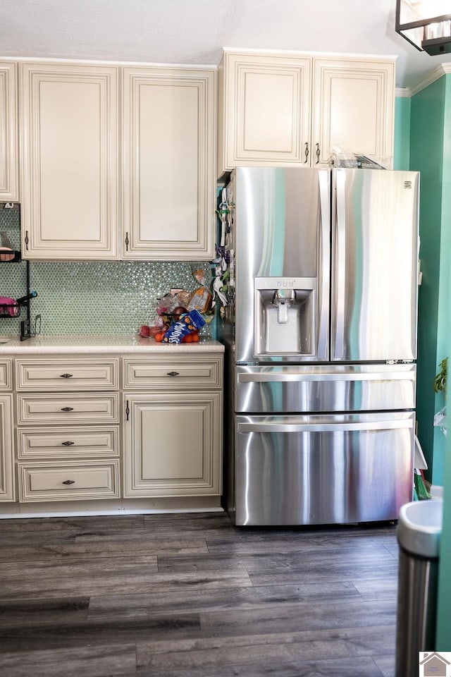 kitchen featuring dark wood finished floors, light countertops, cream cabinetry, tasteful backsplash, and stainless steel fridge