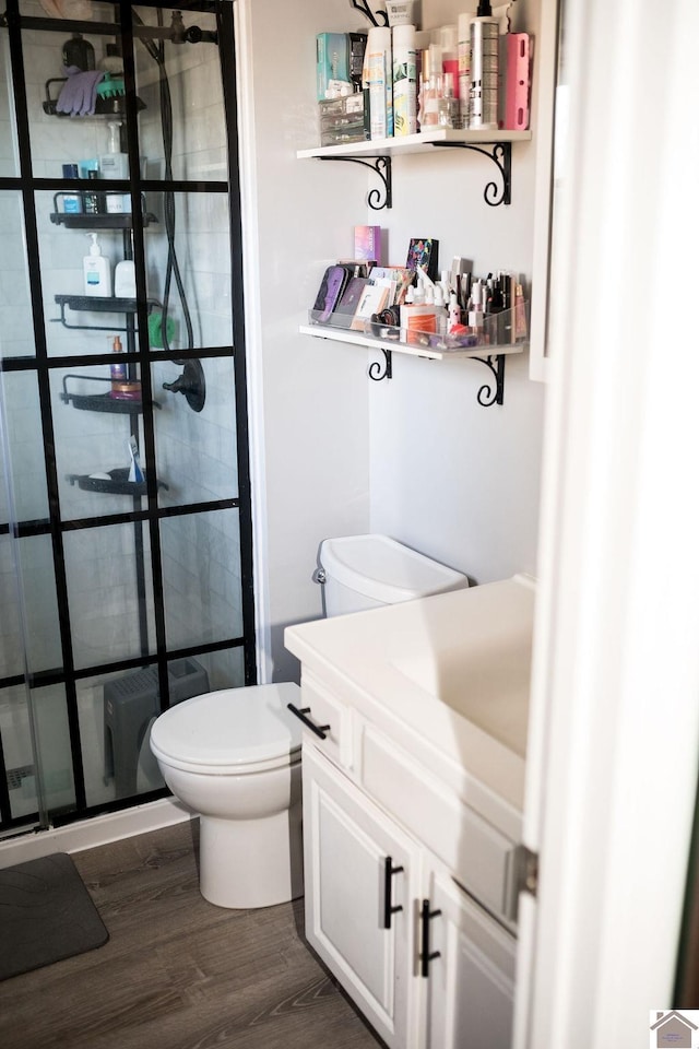 full bath featuring toilet, a shower stall, wood finished floors, and vanity