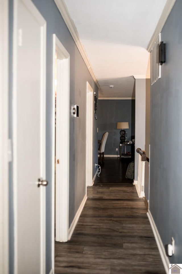 corridor with crown molding, baseboards, and wood finished floors