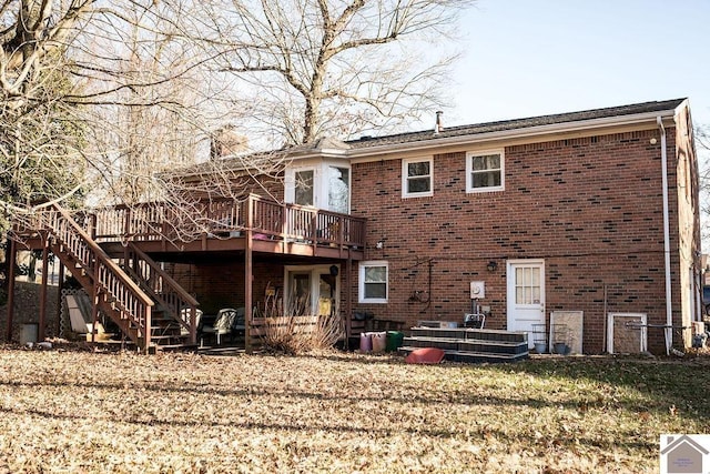 rear view of house featuring a wooden deck and a lawn