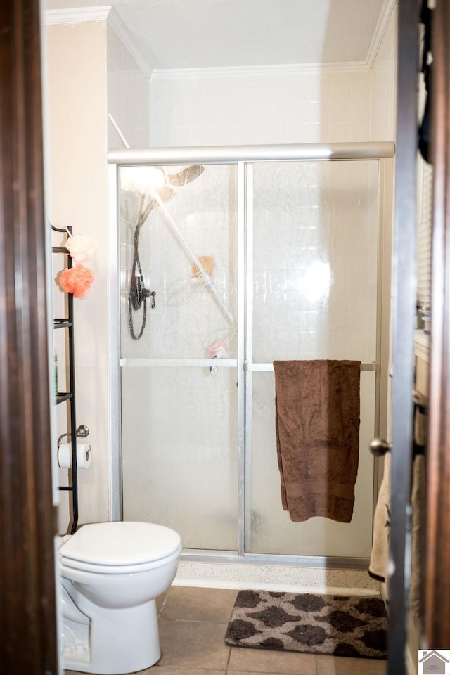 bathroom featuring a stall shower, toilet, and crown molding