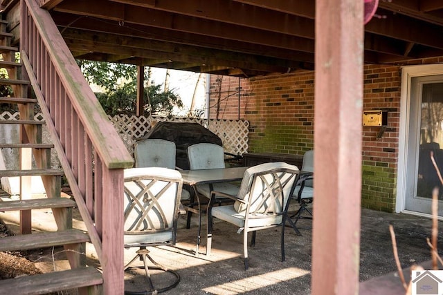 view of patio with outdoor dining area and stairs