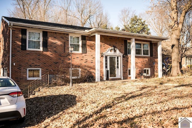 split foyer home featuring brick siding