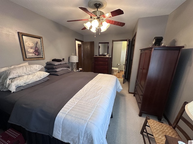 carpeted bedroom featuring ceiling fan and ensuite bathroom