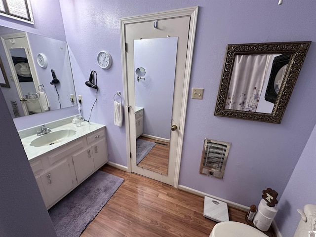 bathroom featuring hardwood / wood-style flooring, vanity, and heating unit