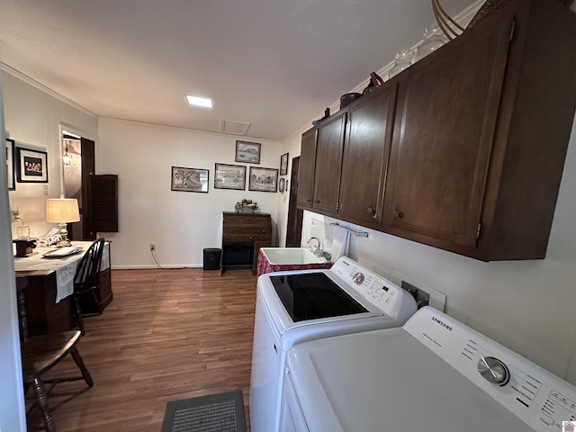 laundry room featuring separate washer and dryer, sink, dark hardwood / wood-style flooring, and cabinets