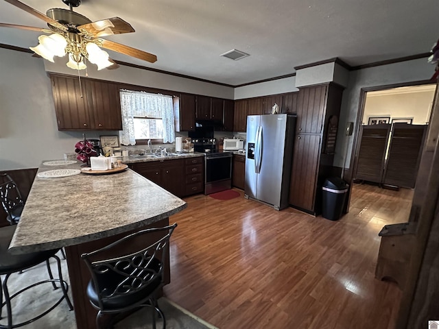 kitchen featuring dark hardwood / wood-style flooring, sink, dark brown cabinets, and stainless steel appliances