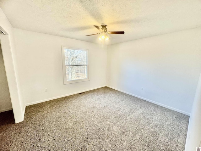 unfurnished room with a textured ceiling, carpet floors, and ceiling fan