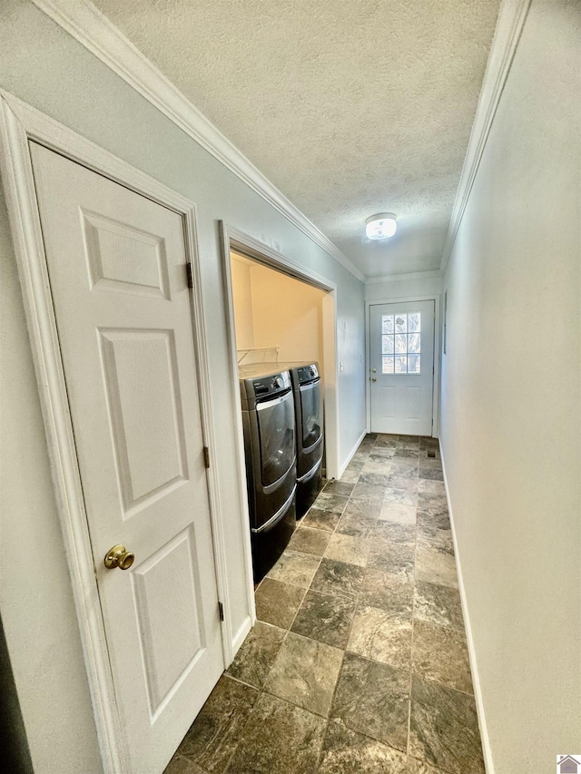 laundry room featuring ornamental molding, washer and dryer, and a textured ceiling