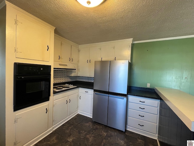 kitchen featuring white cabinetry, white electric cooktop, oven, and stainless steel refrigerator