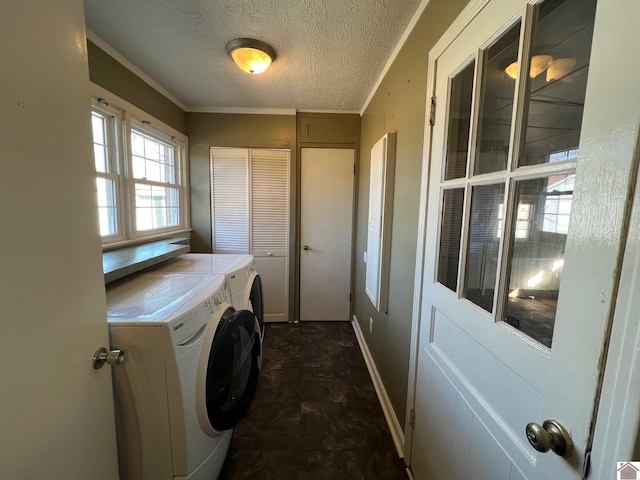 laundry area featuring ornamental molding, separate washer and dryer, and a textured ceiling