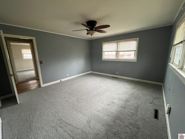 unfurnished room with crown molding, ceiling fan, and carpet flooring