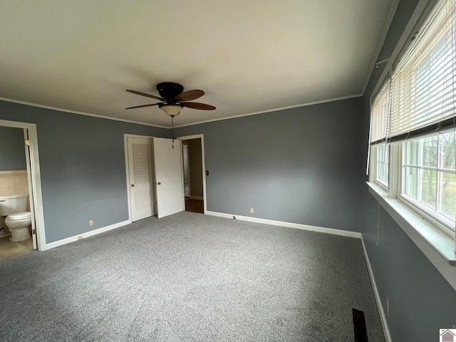 unfurnished bedroom featuring ensuite bathroom, crown molding, a closet, and carpet