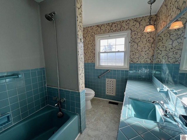 bathroom with shower / bathtub combination, tile patterned floors, toilet, and tile walls