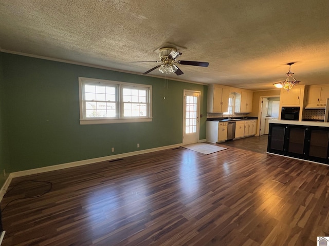 kitchen featuring dark hardwood / wood-style floors, stainless steel dishwasher, black oven, and a textured ceiling