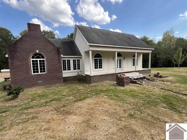 back of house featuring a lawn