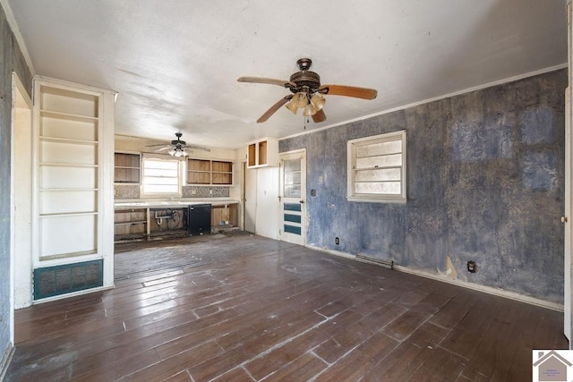 unfurnished living room with ornamental molding, dark hardwood / wood-style floors, sink, and ceiling fan