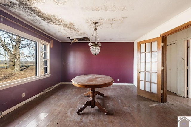 unfurnished dining area featuring an inviting chandelier and wood-type flooring