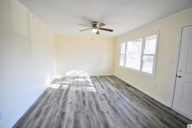 empty room with dark wood-type flooring, ornamental molding, and ceiling fan