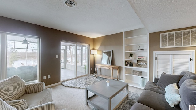 living room with built in features, carpet flooring, and a textured ceiling