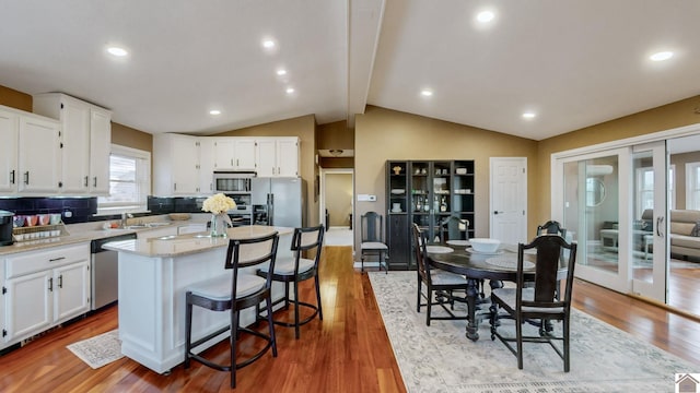 kitchen with light stone counters, a kitchen island, white cabinets, and appliances with stainless steel finishes