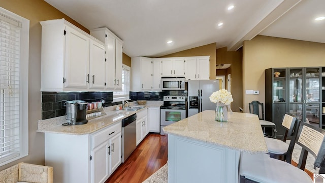 kitchen with white cabinetry, stainless steel appliances, and a center island