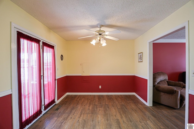 empty room featuring dark wood-type flooring, ceiling fan, and a textured ceiling