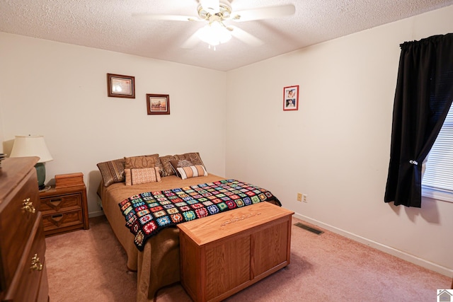 carpeted bedroom with ceiling fan and a textured ceiling