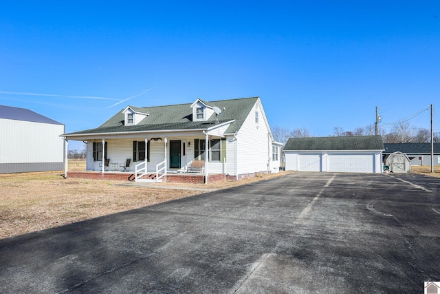 view of front of property featuring an outbuilding, a garage, and covered porch